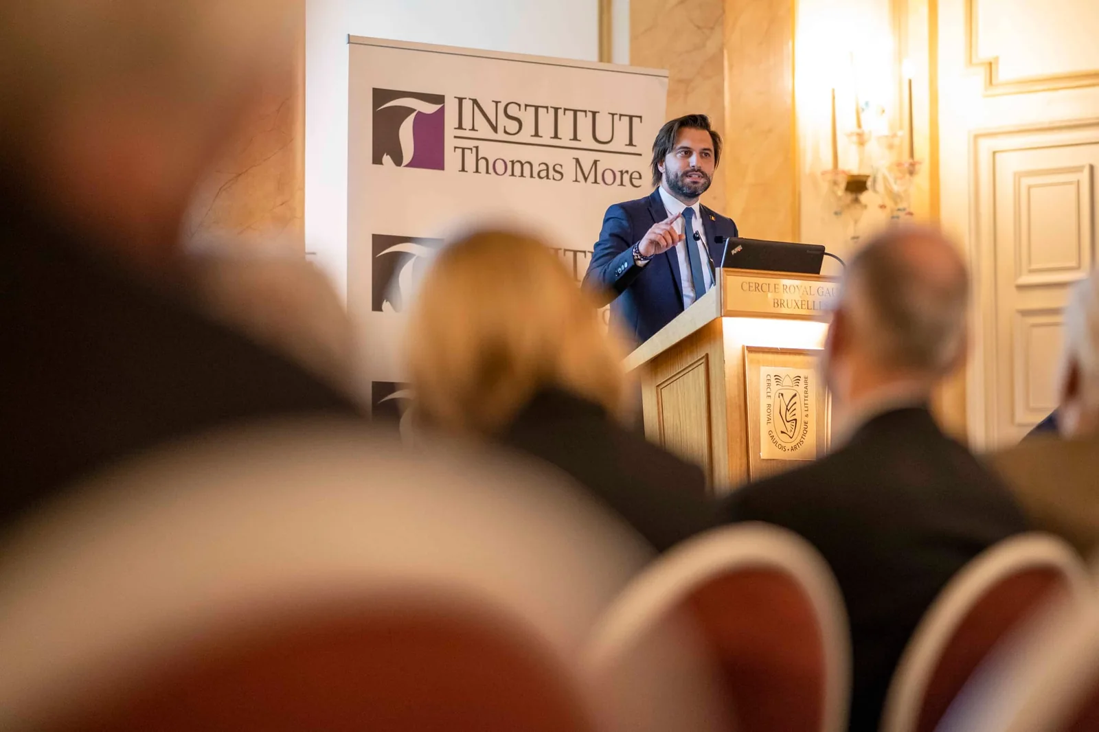 Intervenant au pupitre pendant une conférence, avec le public au premier plan