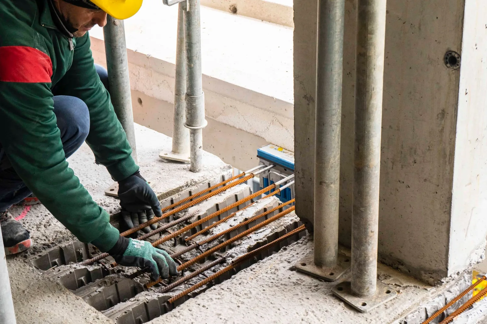 Artisan travaillant sur des installations au sol dans un bâtiment en chantier